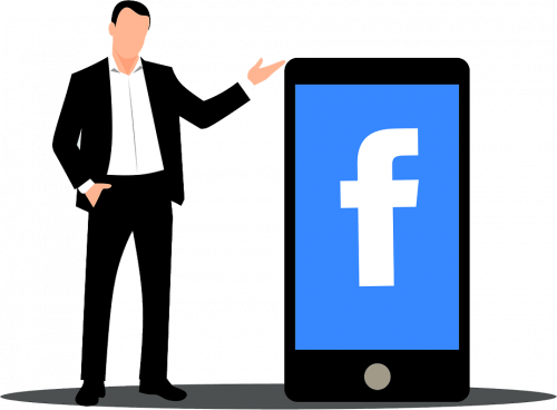man standing beside giant smartphone with facebook logo on screen